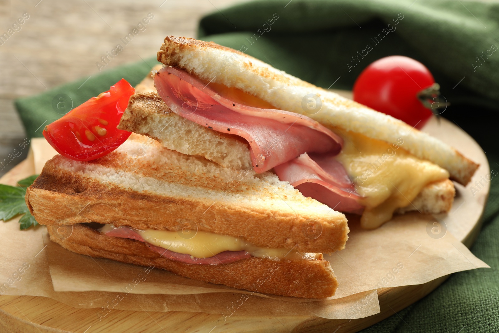 Photo of Tasty sandwiches with ham, tomato and melted cheese on table, closeup