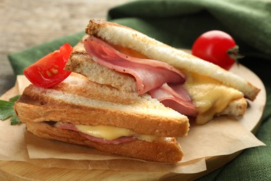 Tasty sandwiches with ham, tomato and melted cheese on table, closeup
