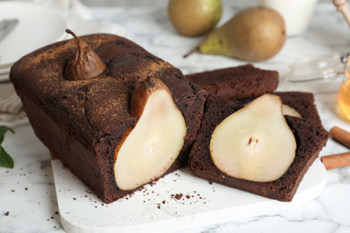 Photo of Tasty pear bread on white marble table. Homemade cake