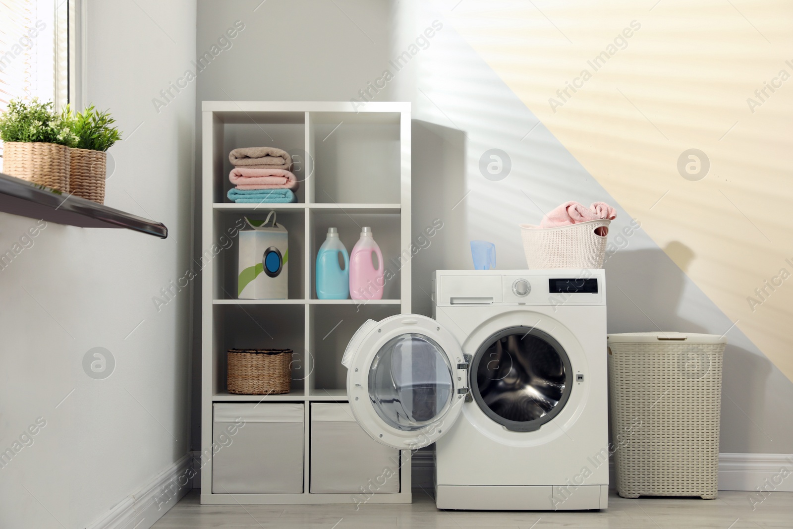 Photo of Modern washing machine in laundry room interior