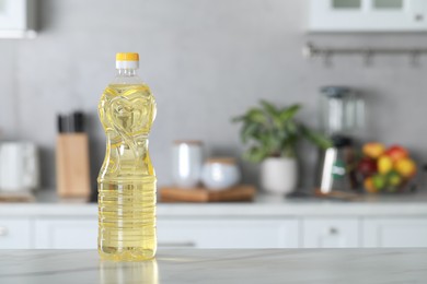 Bottle of cooking oil on white marble table in kitchen. Space for text