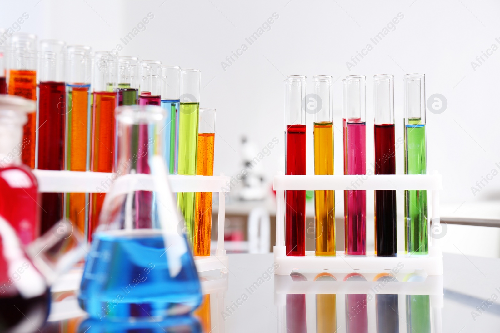 Photo of Laboratory glassware with color liquids on table. Solution chemistry