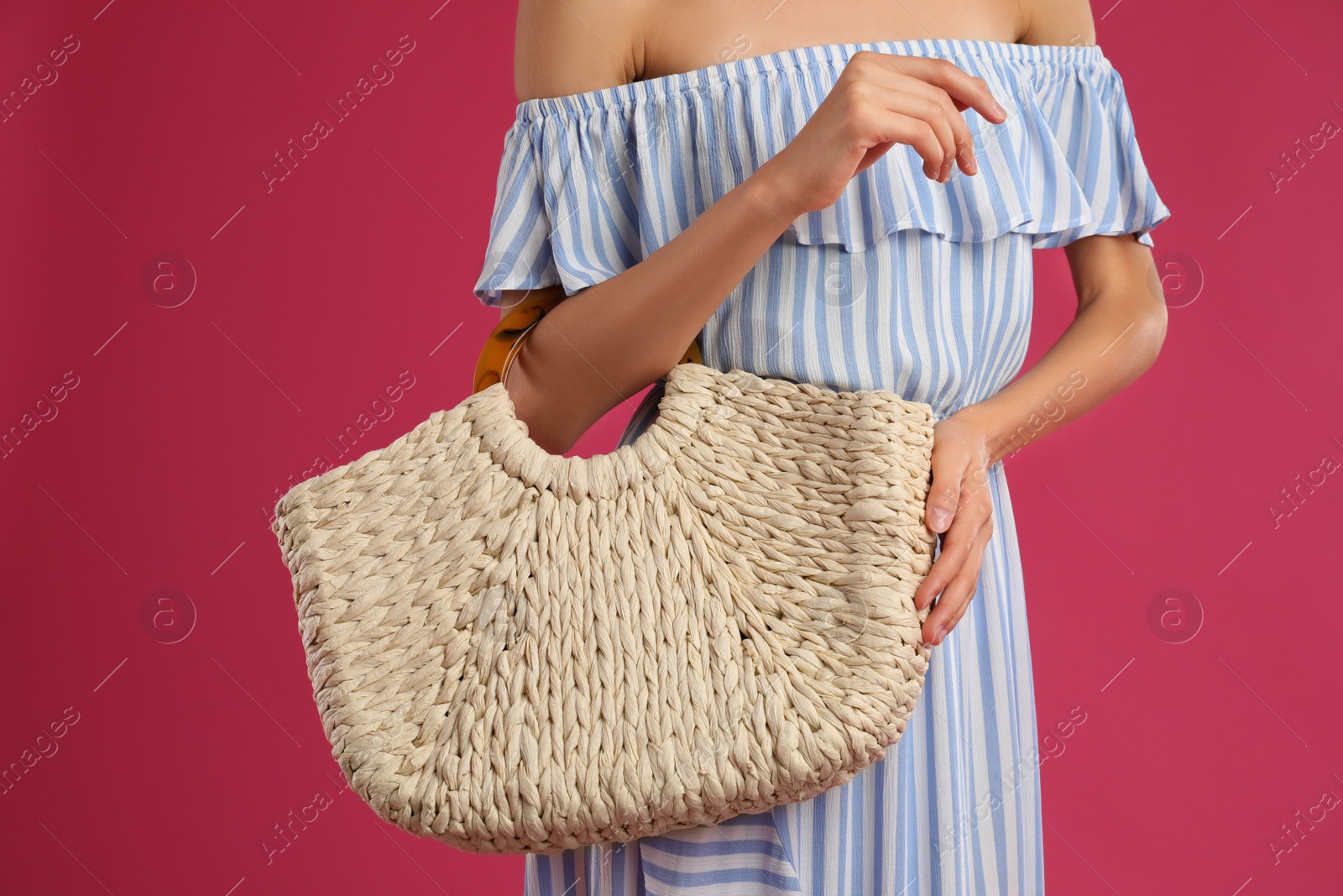 Photo of Young woman with stylish straw bag on pink background, closeup