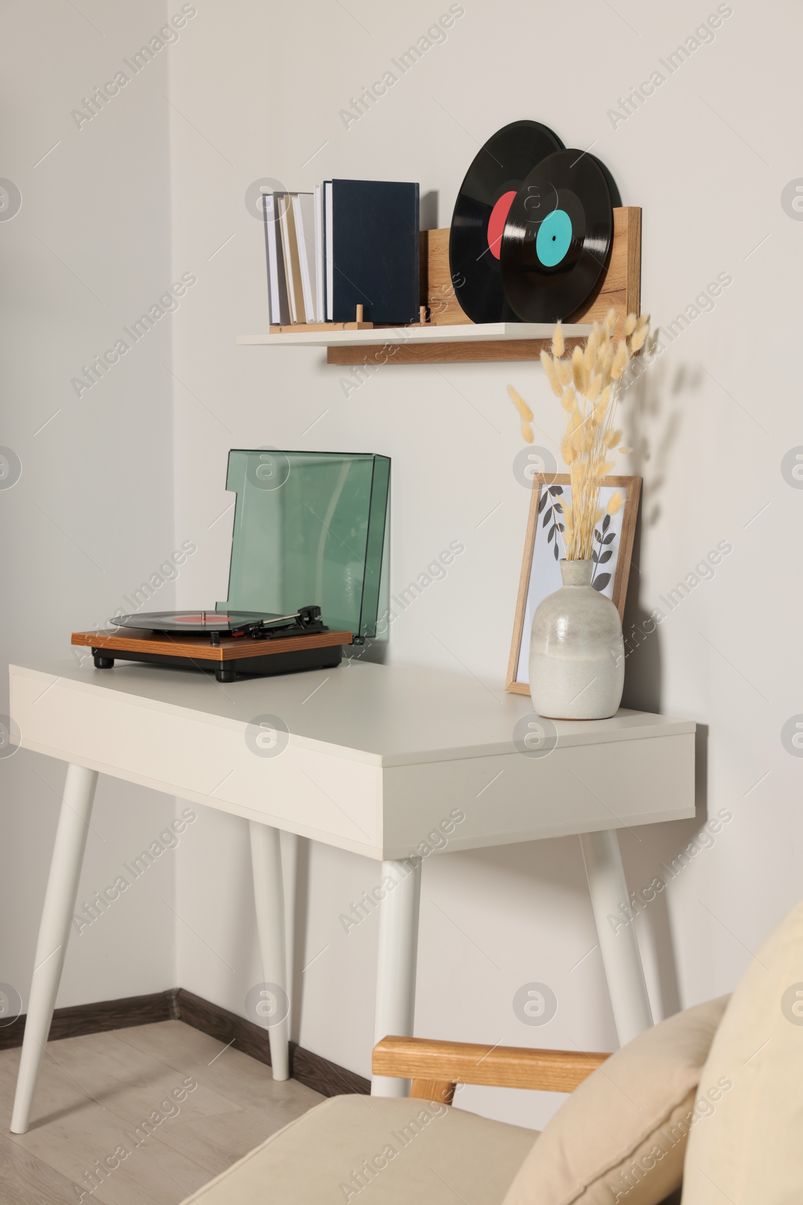 Photo of Room interior with stylish turntable on white table and vinyl records