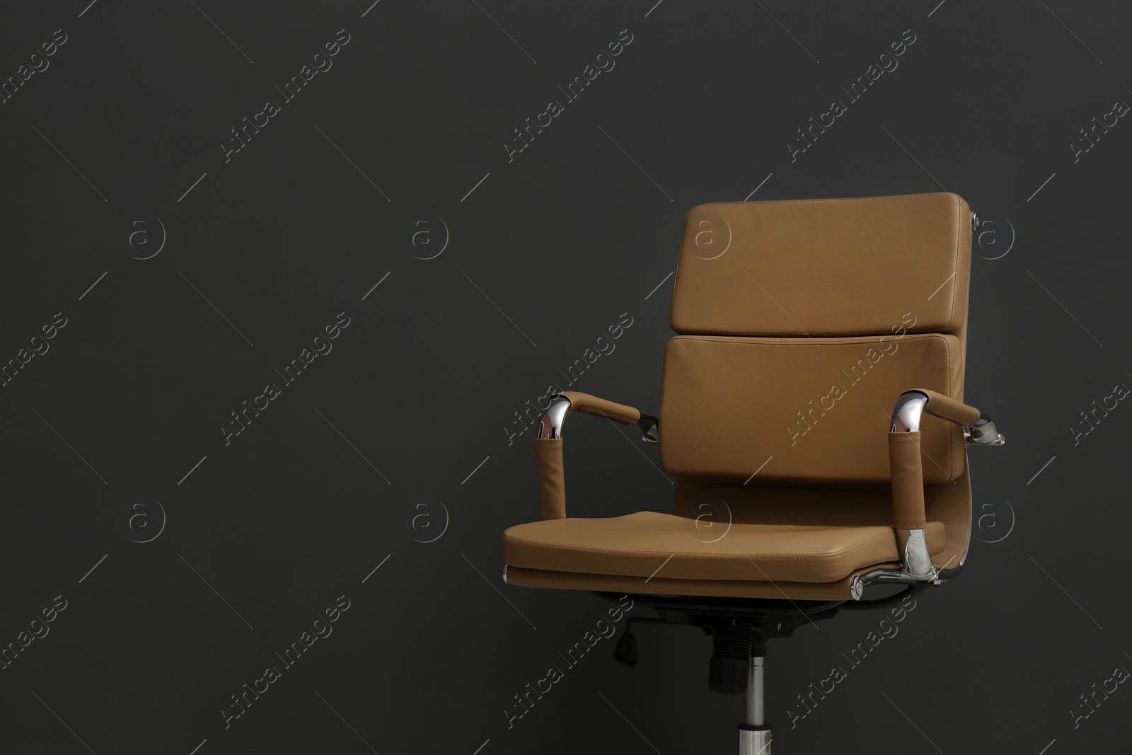 Photo of Comfortable office chair on black background. Space for text