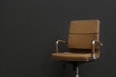 Photo of Comfortable office chair on black background. Space for text