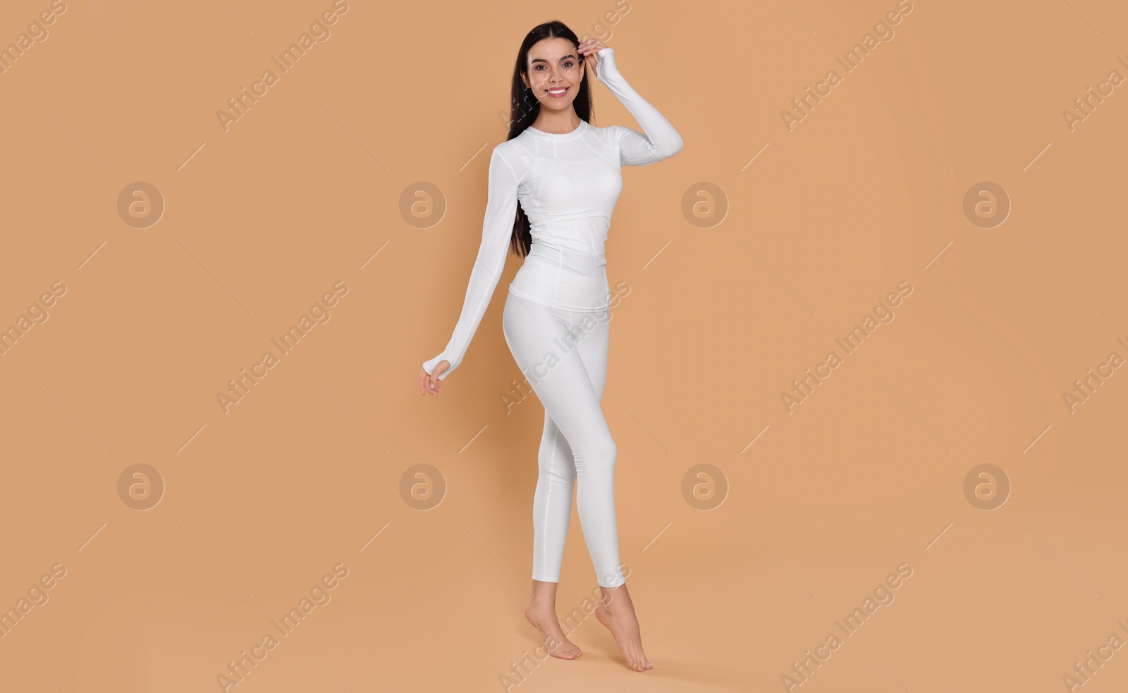 Photo of Woman in warm thermal underwear on beige background. Space for text