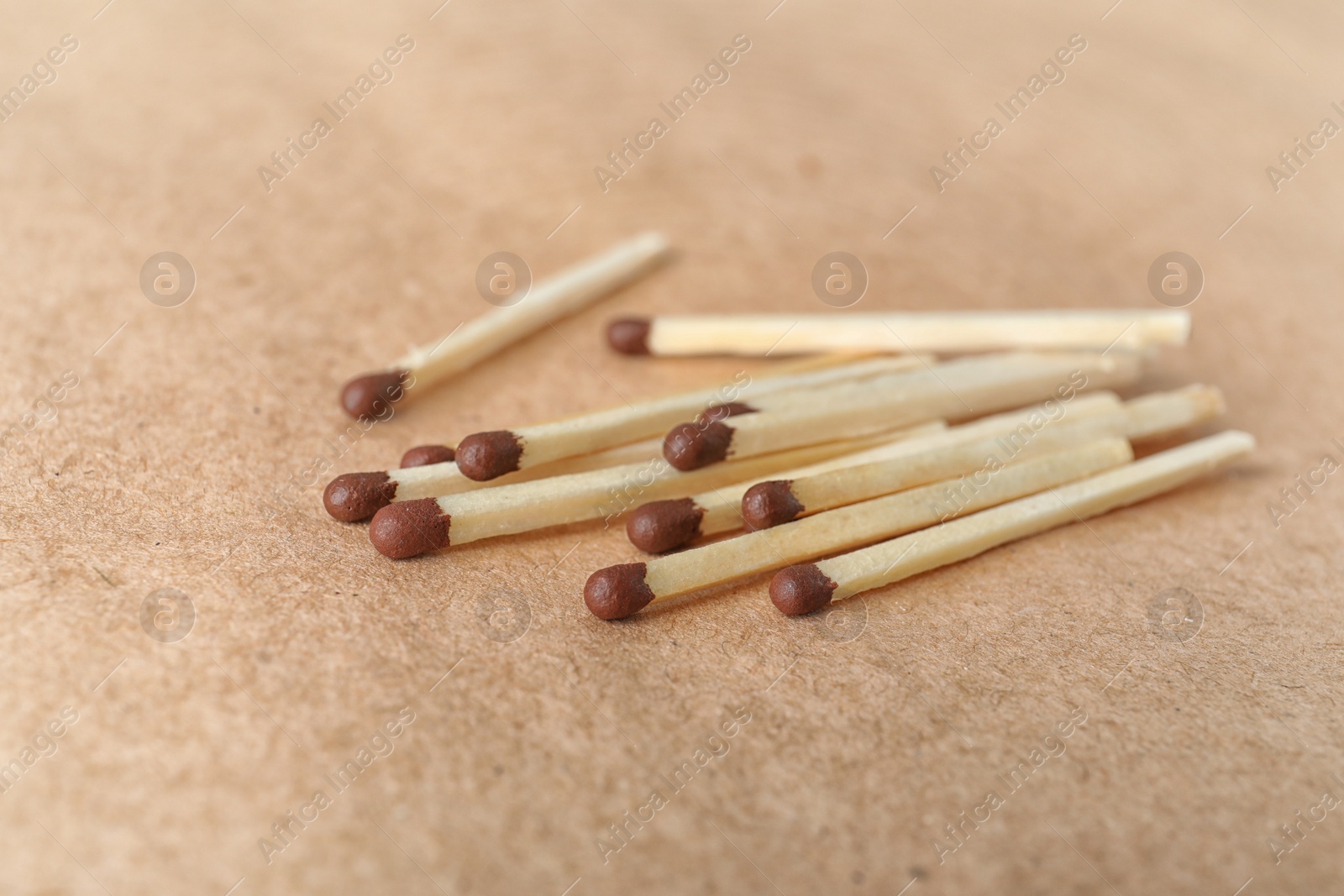 Photo of Heap of matches on brown craft paper, closeup