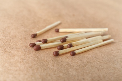 Heap of matches on brown craft paper, closeup