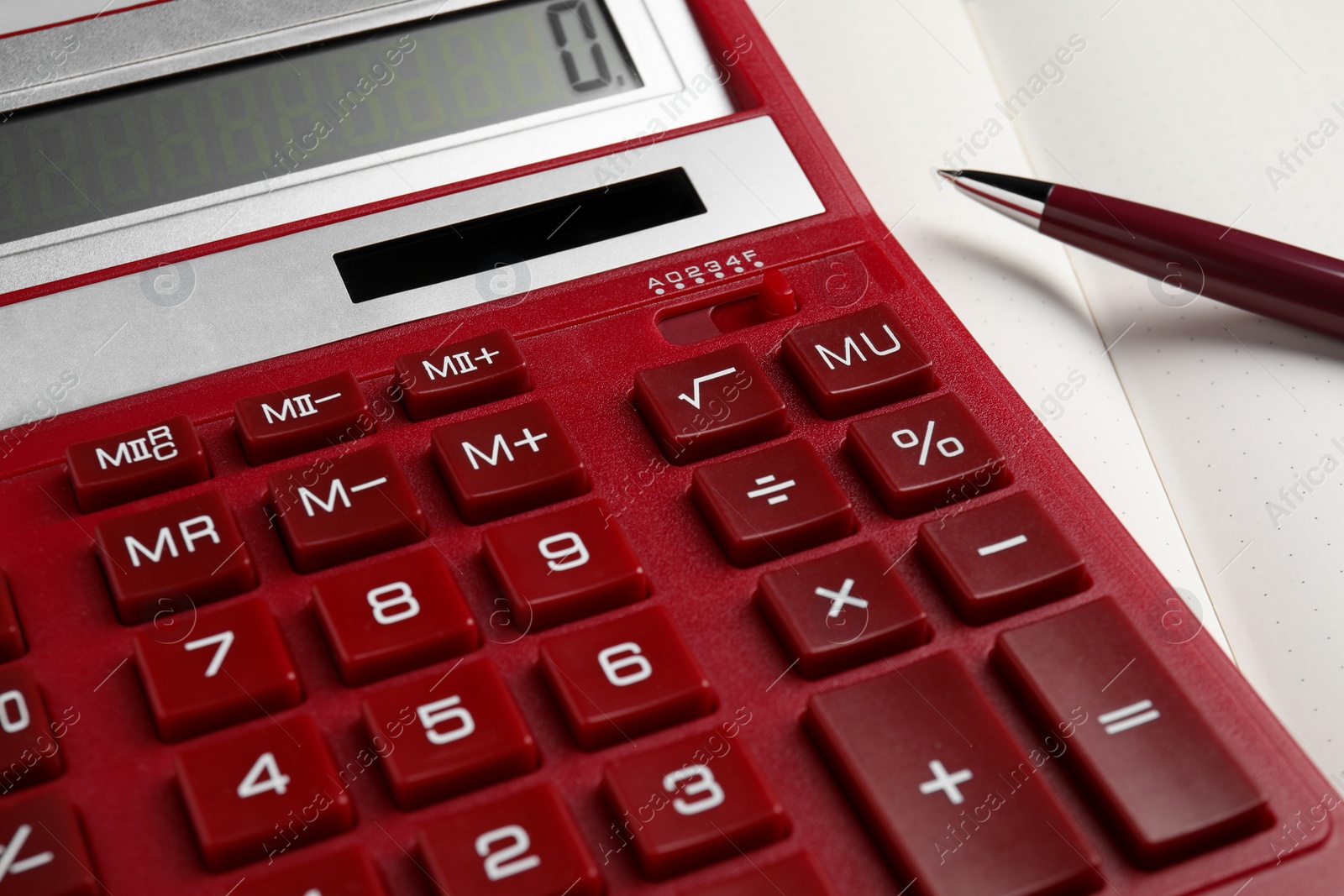 Photo of Calculator and pen on open notebook, closeup