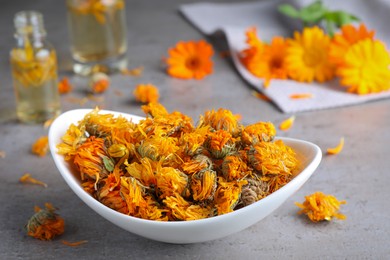 Plate of dry calendula flowers on light grey table