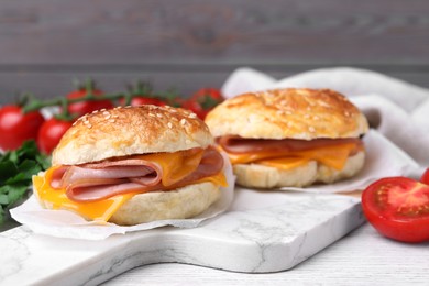 Photo of Delicious bagels with ham and cheese on white table. Space for text