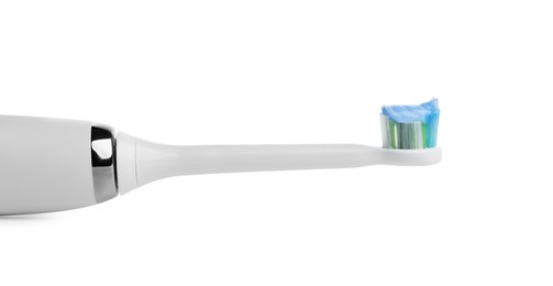 Electric toothbrush with paste on white background, closeup