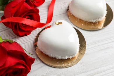 St. Valentine's Day. Delicious heart shaped cakes and roses on white wooden table, closeup