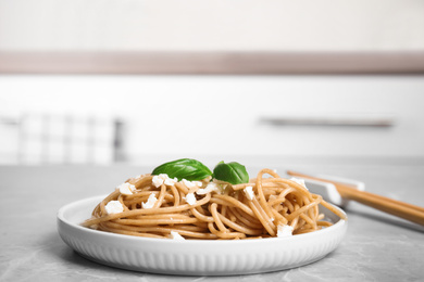 Tasty buckwheat noodles with chopsticks on light grey table