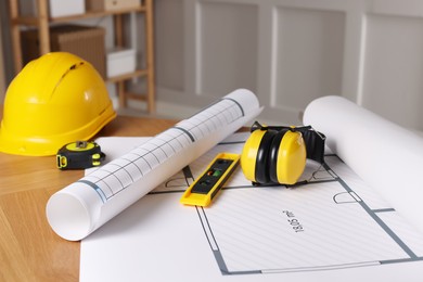 Construction drawings and different tools on table in office