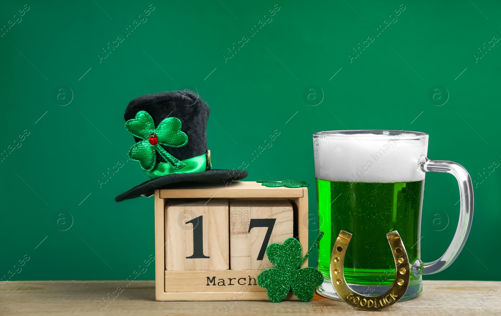 Photo of Composition with green beer and clover on wooden table. St. Patrick's Day celebration