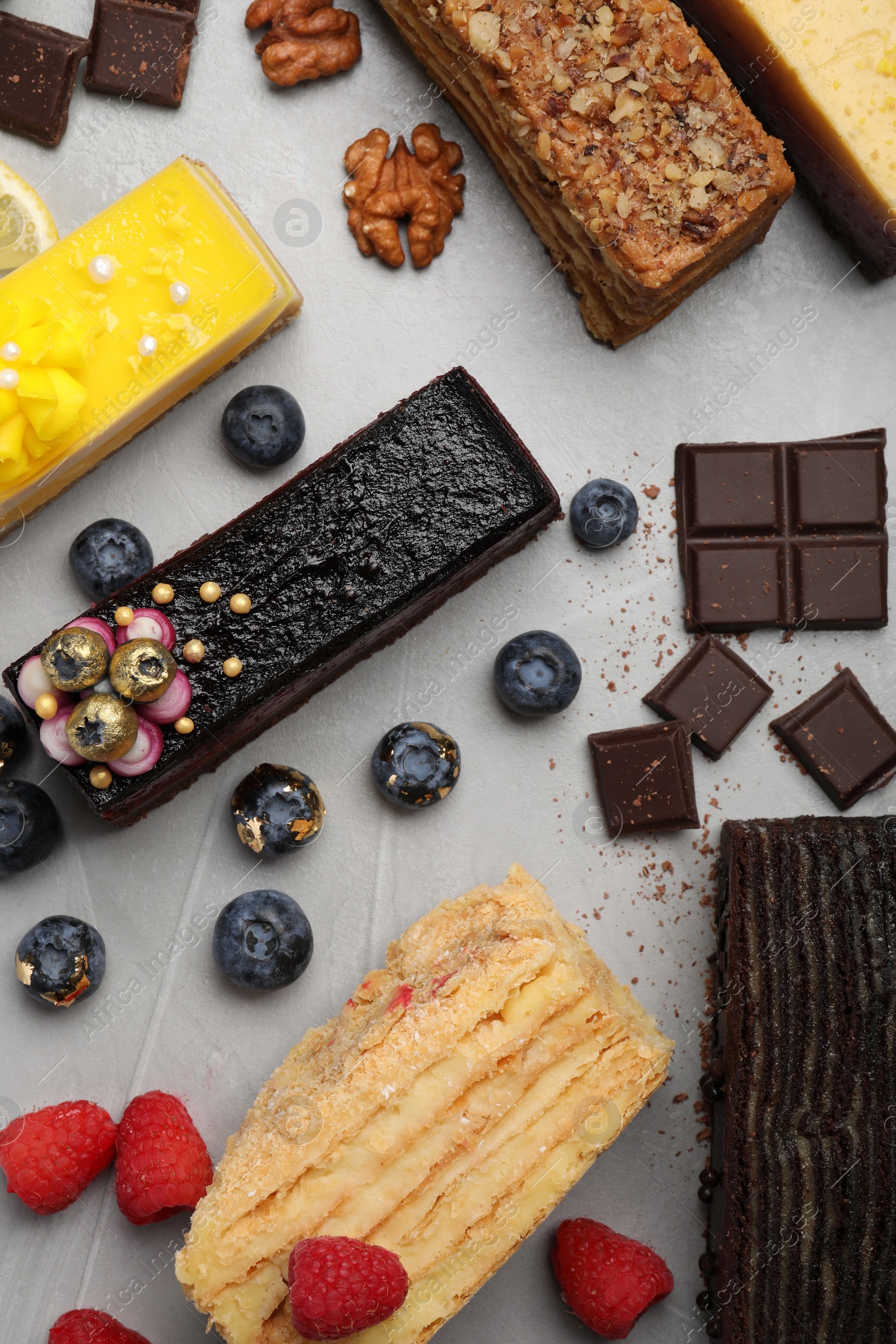 Photo of Flat lay composition with different tasty cakes on light grey table