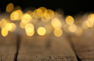 Photo of Yellow Christmas lights on wooden table, blurred view