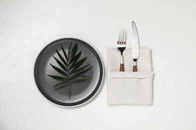 Stylish setting with elegant cutlery on white table, top view