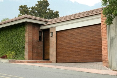 Brick building with closed wooden garage door. Exterior design