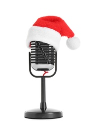 Photo of Retro microphone with Santa hat isolated on white. Christmas music concept