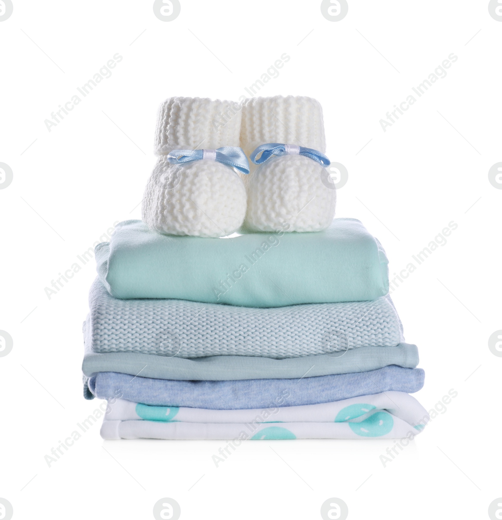 Photo of Stack of clean baby's clothes and small booties on white background