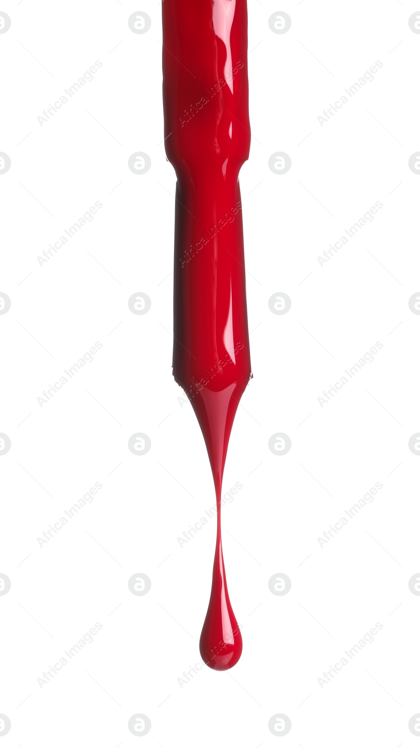 Photo of Red nail polish dripping from brush isolated on white