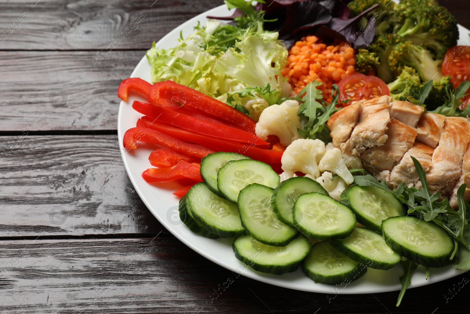 Photo of Balanced diet and healthy foods. Plate with different delicious products on wooden table, closeup. Space for text