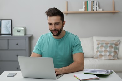 Photo of Online test. Man studying with laptop at home