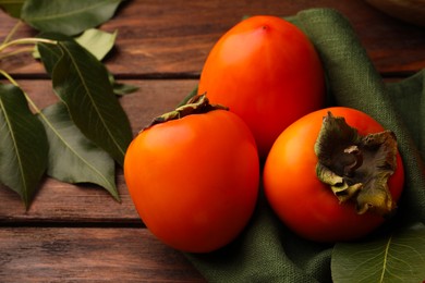 Photo of Delicious ripe juicy persimmons on wooden table