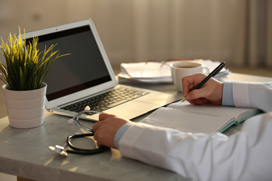 Professional doctor working at table in office, closeup