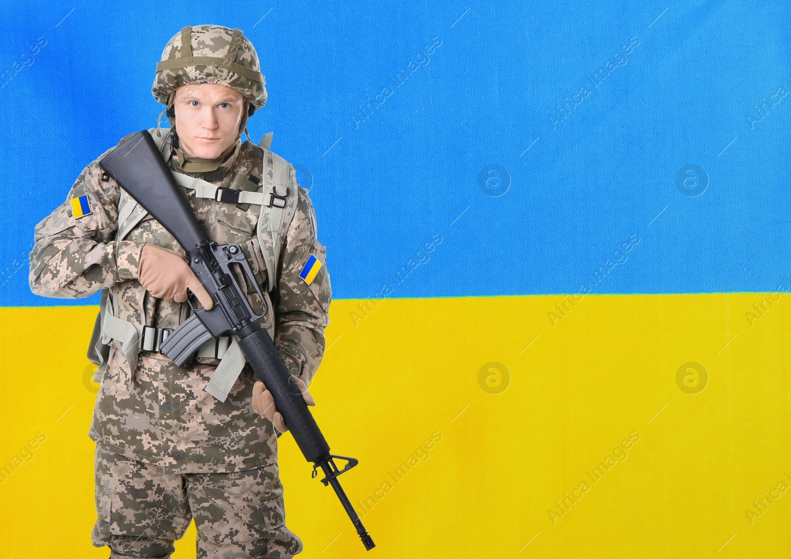 Image of Armed soldier in military camouflage uniform and Ukrainian flag on background, space for text. Stop war