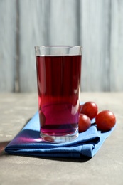 Photo of Delicious grape soda water grey table. Refreshing drink