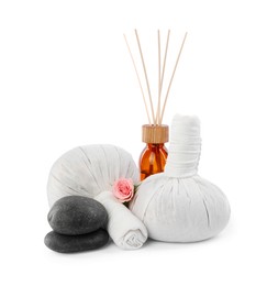 Photo of Herbal massage bags, spa stones and air reed freshener on white background