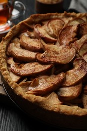 Photo of Delicious apple pie on black wooden table, closeup