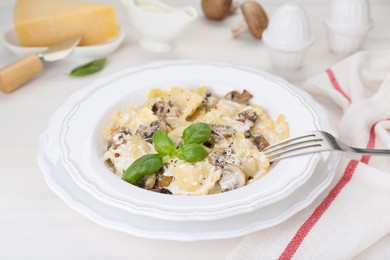 Photo of Delicious ravioli with mushrooms and cheese served on white wooden table