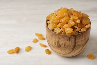 Photo of Bowl with raisins on table, space for text. Dried fruit as healthy snack