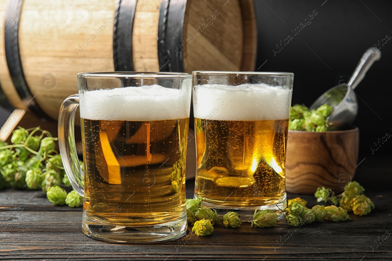 Photo of Composition with tasty beer and fresh green hops on wooden table