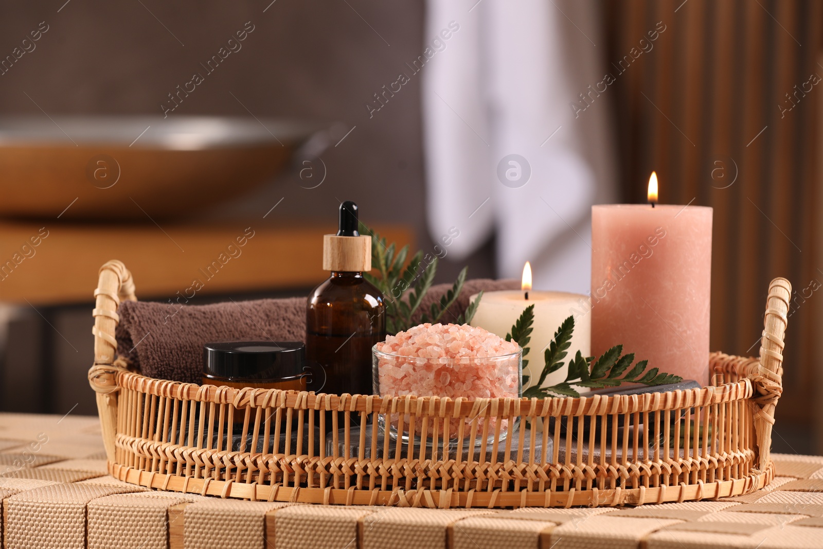 Photo of Beautiful composition with different spa products on wicker bench indoors