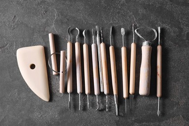 Set of different clay crafting tools on grey table, top view