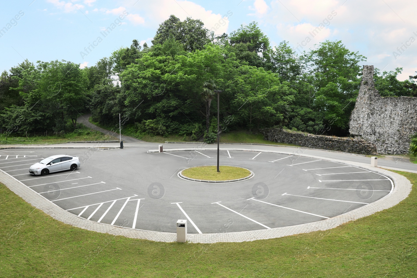 Photo of Car in outdoor parking lot near beautiful green park