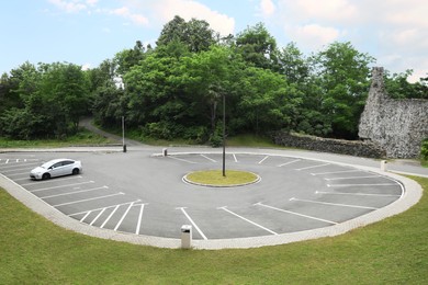 Photo of Car in outdoor parking lot near beautiful green park