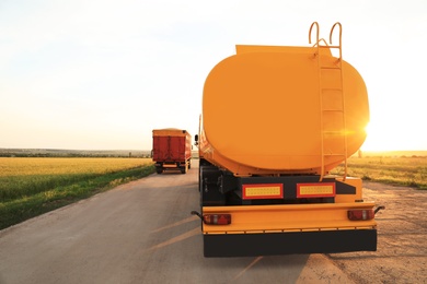 Photo of Modern bright trucks parked on country road