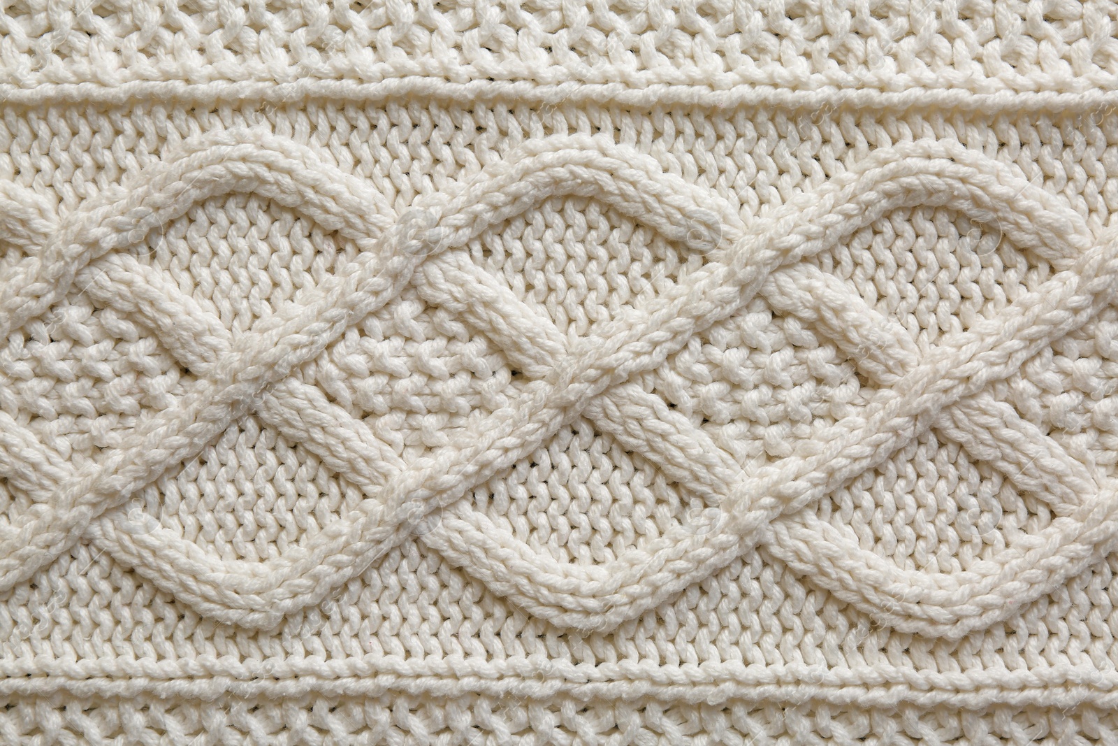 Photo of White knitted fabric with beautiful pattern as background, top view