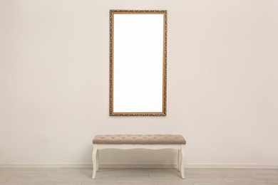 Photo of Frame with empty canvas on wall and bench in modern art gallery. Mockup for design