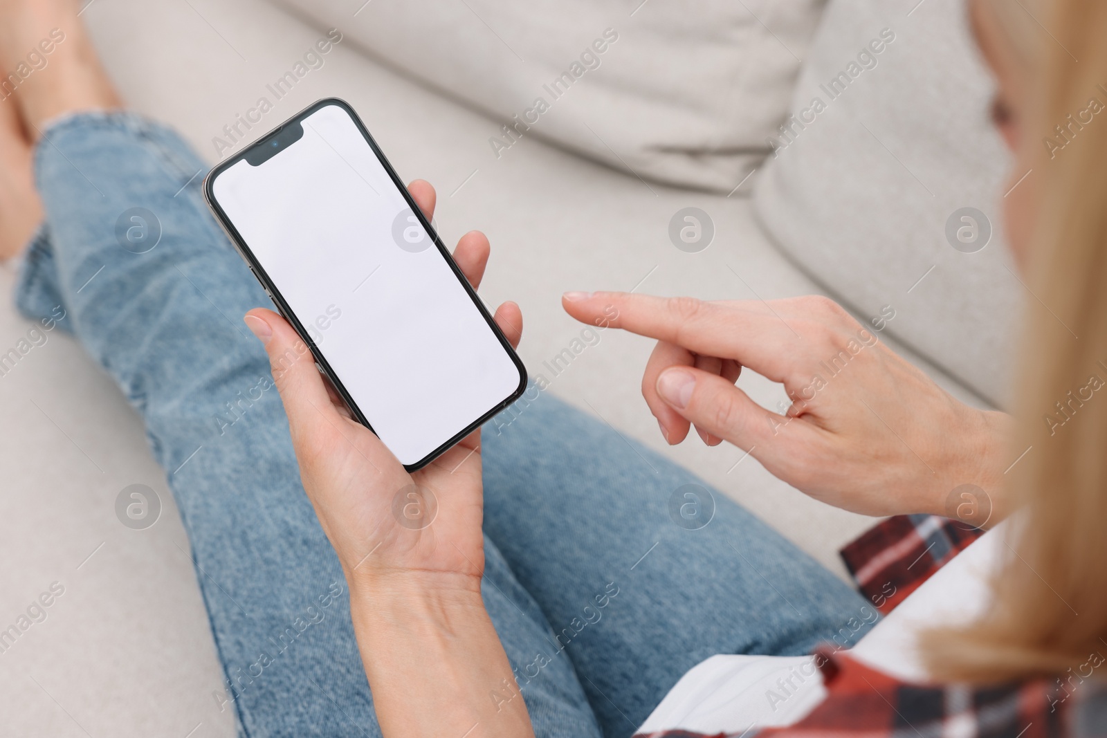 Photo of Woman using smartphone on couch at home, closeup. Space for text