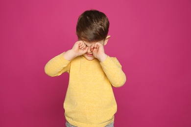 Photo of Little boy rubbing face on color background. Annoying itch