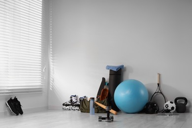 Photo of Many different sports equipment near wall indoors