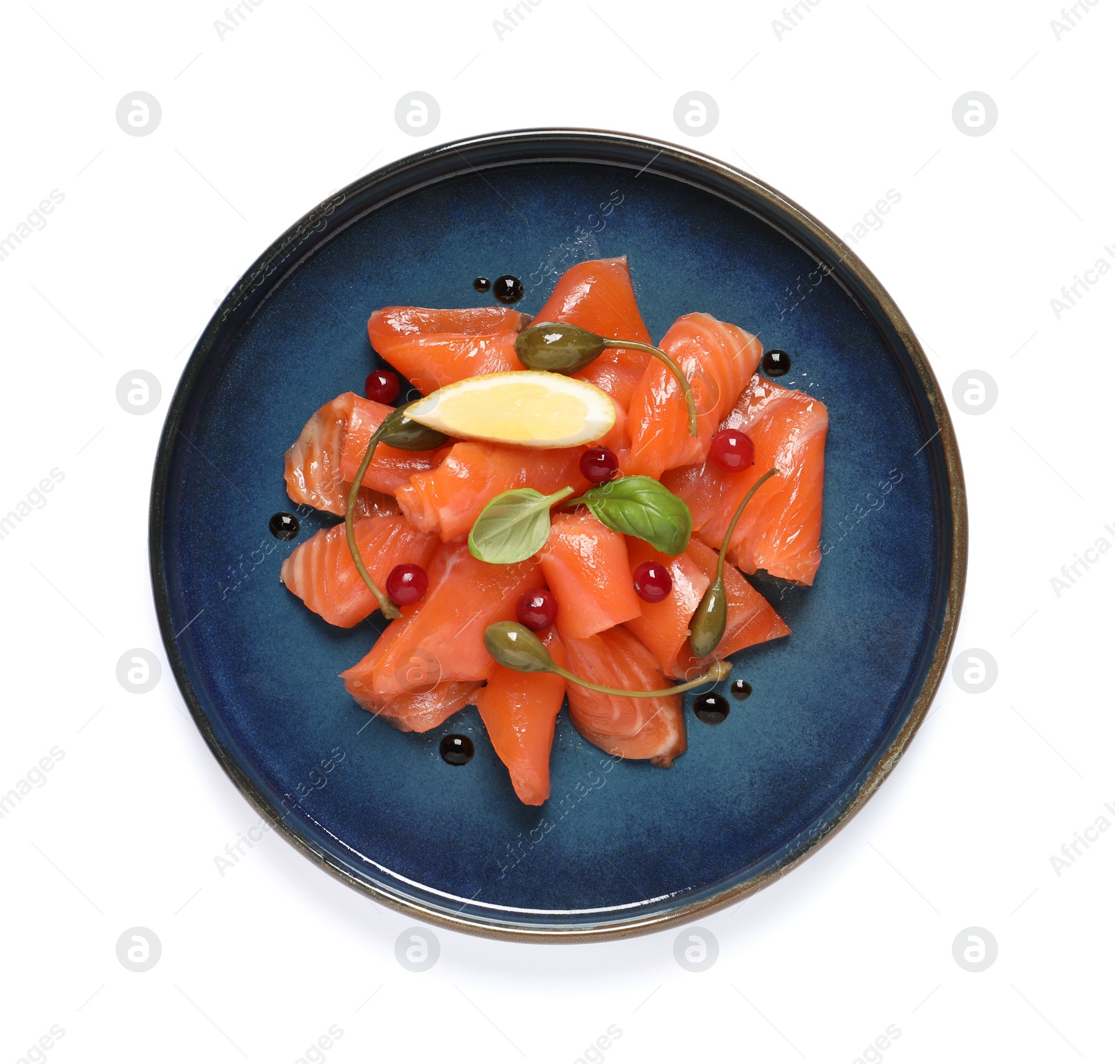 Photo of Salmon carpaccio with capers, cranberries, basil and lemon isolated on white, top view